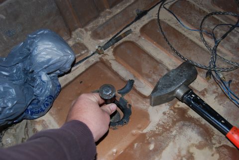 1982 Ford Bronco - Close-up of a hand holding a bolt, with tools and a plastic bag nearby.