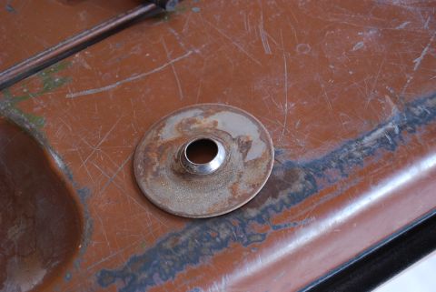 1982 Ford Bronco - Detail of a rusted metal surface a circular washer and bolt head, likely a component from a vehicle's interior or chassis.