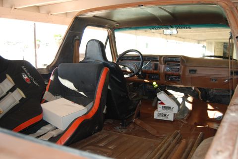 1982 Ford Bronco - The interior of a vintage Ford Bronco shows racing seats and a worn dashboard.