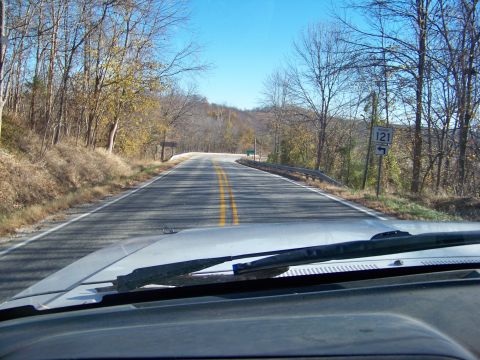 1987 Ford F-250 - Driving down a rural road with trees and a speed limit sign visible.
