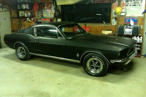 1968 Ford Mustang - A black 1967 Ford Mustang Fastback is parked inside a cluttered garage.