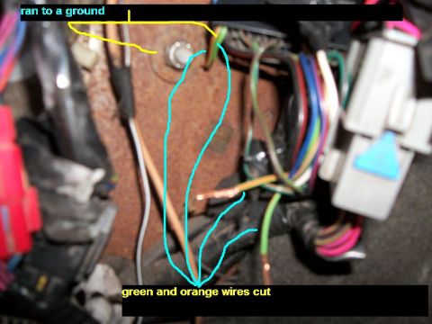 1992 Jeep Cherokee - Close-up view of a vehicle's wiring harness, showing cut green and orange wires and a connection to ground.