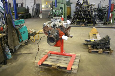 1973 Ford Ranchero - A Ford V8 engine is displayed on a stand in a workshop environment.