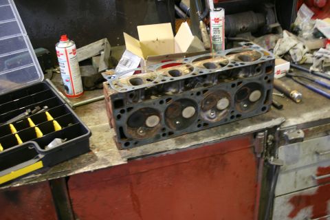 1973 Ford Ranchero - A disassembled engine cylinder head sits on a workbench, ready for repair or replacement.