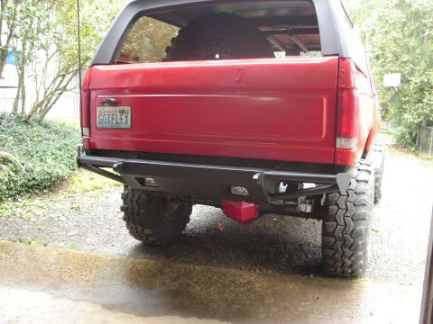 1989 Ford Bronco - Rear view of a red 1989 Ford Bronco a custom bumper and a spare tire mounted inside.