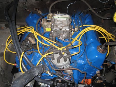 1979 Ford Bronco - The engine bay features a blue painted engine block with yellow spark plug wires and a prominent carburetor.