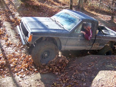 1987 Ford F-250 - This pickup truck, likely a Jeep Comanche from the mid-1980s, is shown tackling an off-road course.