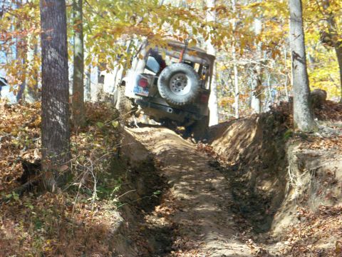 1987 Ford F-250 - A Jeep Wrangler tackles a challenging off-road trail during a wheeling trip in the woods.