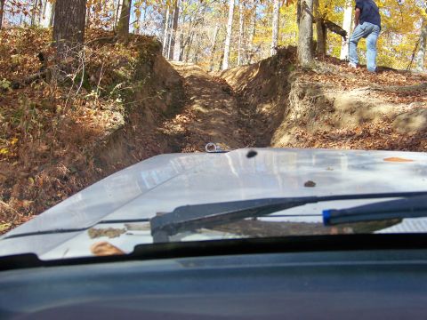 1987 Ford F-250 - Driving up a steep, muddy off-road trail in a wooded area during autumn.