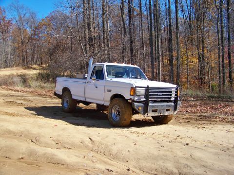 1987 Ford F-250 - This lifted 1987 Ford F-250 pickup truck is shown off-road with a tall exhaust pipe and bull bar.