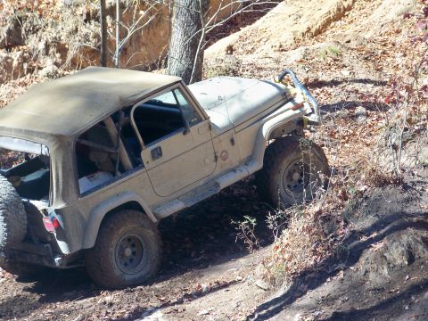 1987 Ford F-250 - Jeep Wrangler TJ navigating an off-road trail with steep inclines and loose dirt.
