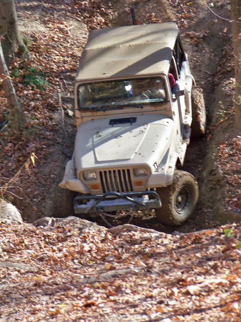 1987 Ford F-250 - A Jeep navigates a challenging off-road path during a sunny day excursion.