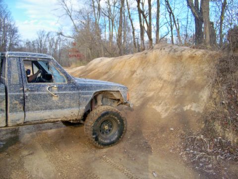 1987 Ford F-250 - A dirty pickup truck navigates a challenging off-road trail.