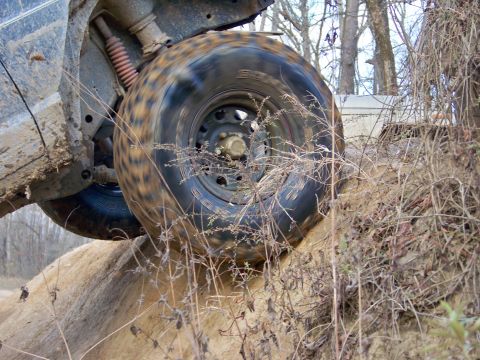 1987 Ford F-250 - A vehicle navigates a steep dirt incline during an off-road excursion.
