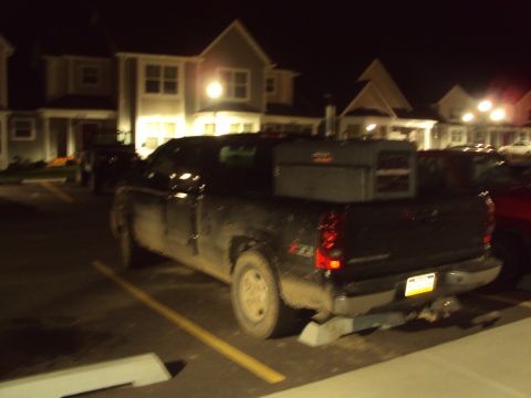 2003 Chevrolet Silverado 1500 - Rear view of a black 2003 Chevrolet Silverado 1500 pickup truck parked at night.