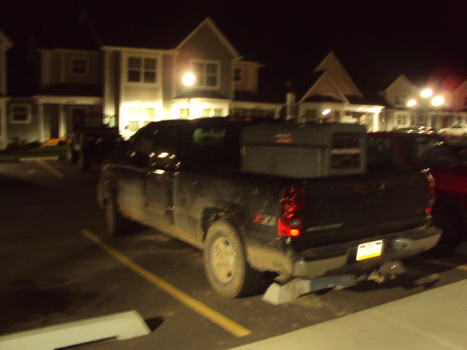 2003 Chevrolet Silverado 1500 pickup truck parked at night, rear view with toolbox in bed