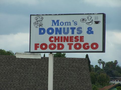 1990 Ford Bronco - A sign advertises Mom's Donuts & Chinese Food Togo, with images of a donut, croissant, and coffee cup.