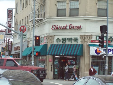 1990 Ford Bronco - Urban street scene with multiple businesses and vehicles, including a red SUV.