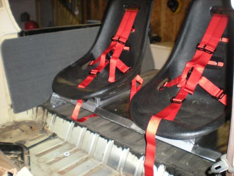 1978 Ford Bronco - Aftermarket racing seats with red harnesses are shown installed in the interior of a vehicle, with the floor and rear panel visible.