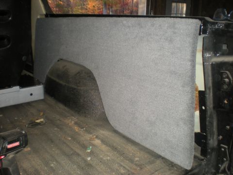 1978 Ford Bronco - Interior view of a vehicle's rear quarter panel and wheel well, carpeted and showing the floor.