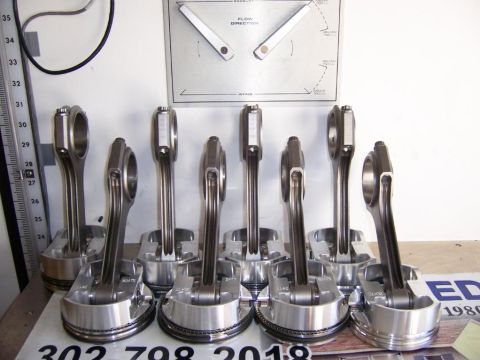 2006 Chevrolet Corvette - A collection of engine pistons and connecting rods are displayed in front of a flow direction diagram.