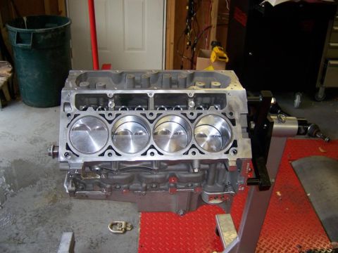 2006 Chevrolet Corvette - Engine block with pistons on a stand in a garage setting.