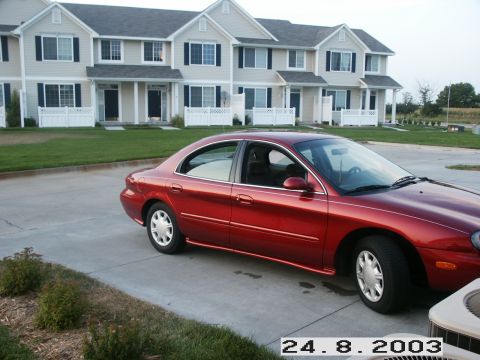 1998 Mercury Sable - Red 1998 Mercury Sable sedan parked in front of a row of townhouses.