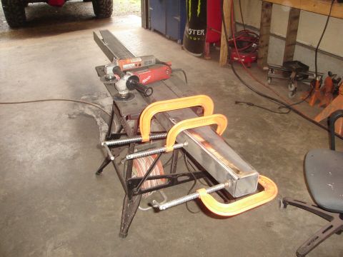1989 Ford Bronco - Metal fabrication setup with angle grinders and a chop saw on a workbench.