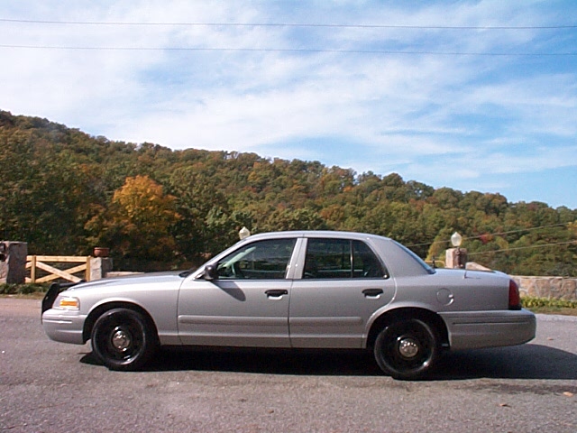 Silver Ford Crown Victoria sedan side profile with black steel wheels
