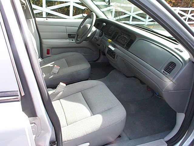 Gray cloth interior of a 2004 Ford Crown Victoria, showing front seats, dashboard, and steering wheel