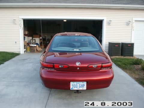 1998 Mercury Sable - Rear view of a red sedan parked in front of a garage. The license plate reads 980 GHP.