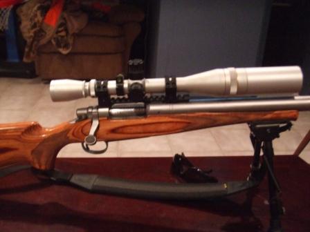 1996 Ford Bronco - A rifle equipped with a scope and bipod is displayed, with a Supermotors logo visible at the bottom.