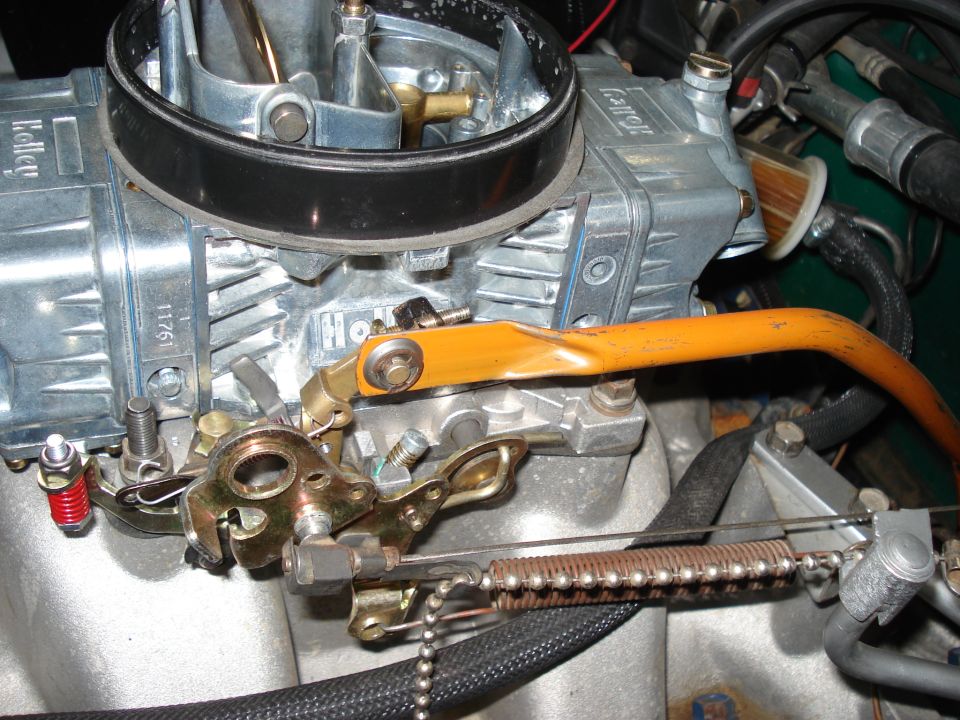 Holley carburetor with orange throttle linkage and visible part numbers