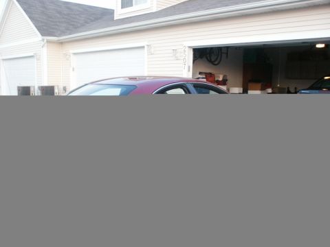 1998 Mercury Sable - A red sedan is parked in front of a garage with another vehicle visible inside.