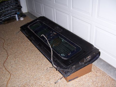 1992 Ford Bronco - A detached car door is shown indoors, placed on a box in front of a garage door.