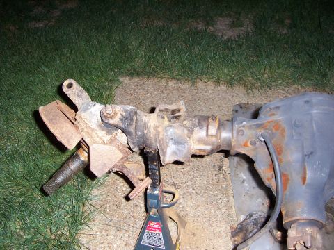 1992 Ford Bronco - Front axle assembly with brake components and differential housing, resting on jack stands.