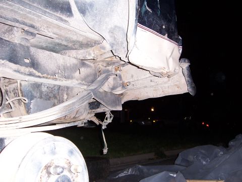1992 Ford Bronco - The rear suspension and axle of a 1992 Ford Bronco are visible, along with a damaged rear body panel.