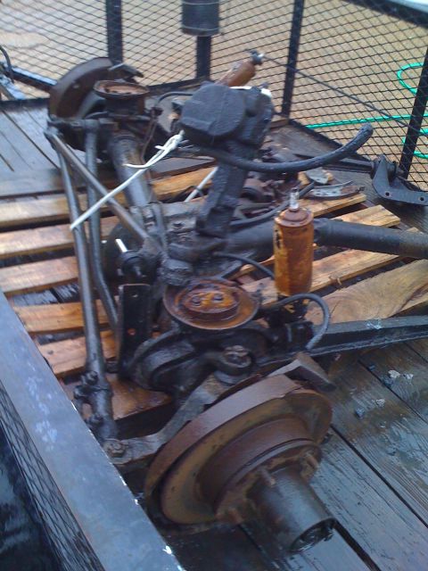 1992 Ford Bronco - A disassembled front axle assembly, likely for a truck or SUV, is shown on a wooden surface.