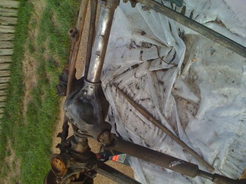 1992 Ford Bronco - Front axle assembly, likely from a Ford Bronco, laid out on plastic sheeting.