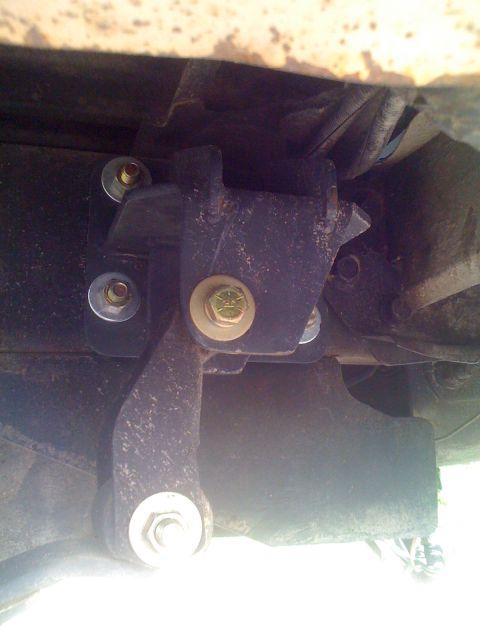 1992 Ford Bronco - Underside view of a vehicle's suspension system, showing a bracket and bolts.