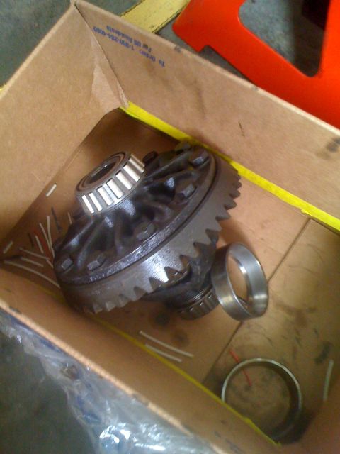 1992 Ford Bronco - A differential carrier, likely for a vehicle's drivetrain, is shown inside a cardboard box with its associated bearings.
