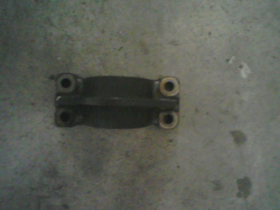 Dark metal part with four bolt holes