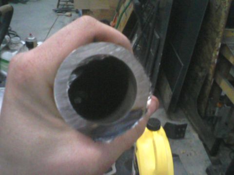 1993 Ford Bronco - Close-up of a metal pipe being held, with a yellow jug visible in the background.