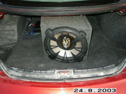 1998 Mercury Sable - A Kicker subwoofer is installed in the trunk of a red car.