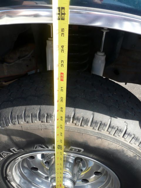 1995 Ford Bronco - A tape measure is used to show the ground clearance of a 1995 Ford Bronco's front tire and suspension.