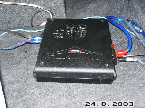 1998 Mercury Sable - A Kicker car amplifier is shown with its wiring, installed in a vehicle's carpeted interior.