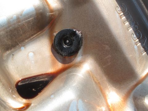 1995 Ford Bronco - The transmission pan shows a drain plug and some dark fluid, indicating it's part of a vehicle's drivetrain.