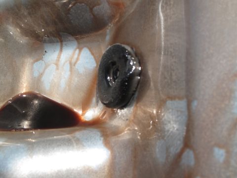 1995 Ford Bronco - Close-up view of a transmission pan interior, showing fluid and a bolt.
