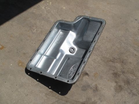 1995 Ford Bronco - A Ford-branded transmission pan is shown from above, lying on a concrete surface.