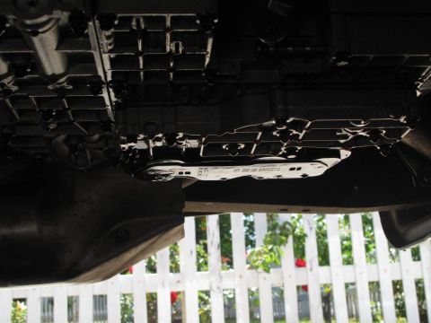 1995 Ford Bronco - Close-up of a transmission pan, showing part numbers and mounting bolts.